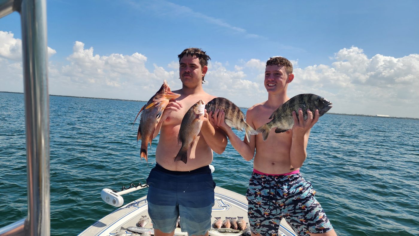 Two guests holding up hogfish and sheepshead